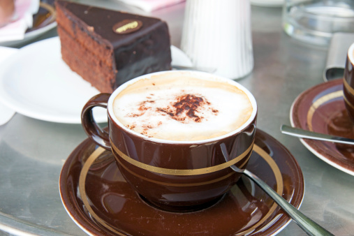 Cappuccino in a bar with a slice of chocolate cake