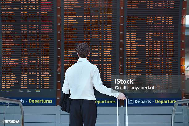 Passenger Looking At Timetable Board Stock Photo - Download Image Now - Airport, Commercial Airplane, Waiting