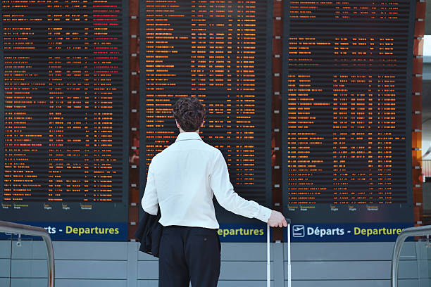 pasażer patrząc na harmonogram zarządu - arrival departure board airport travel business travel zdjęcia i obrazy z banku zdjęć