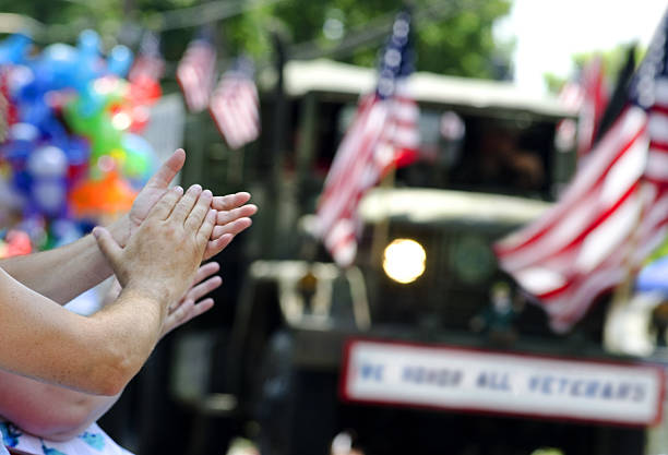 mains, taper dans les mains sur veterans parade - défilé photos et images de collection