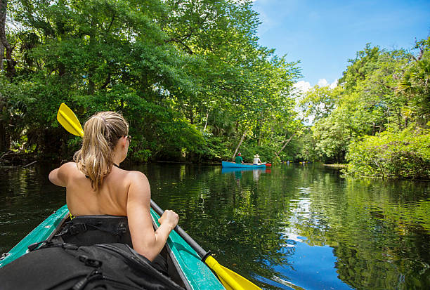 istock Woman Kayaking down a beautiful tropical jungle river 475705404