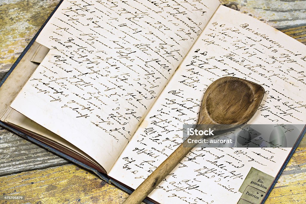 Recipe book with wooden spoon Grandmothers cookbook with spoon on the kitchen table Recipe Stock Photo