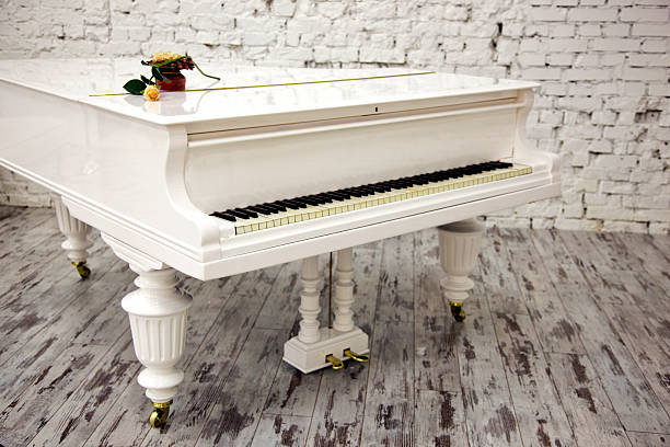 istock White piano with beautiful yellow rose 475706721
