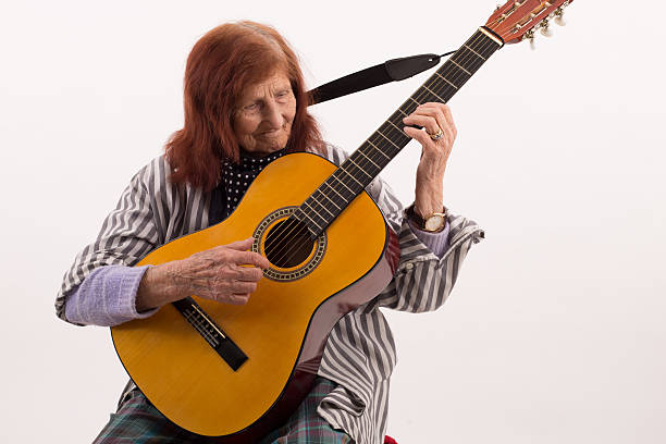 istock Funny elderly lady playing acoustic guitar 475706778