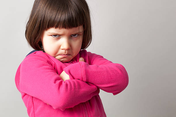 frustrated young child sulking with crossed arms and dirty look unhappy boyish 4-year old girl expressing disagreement with body language disgust stock pictures, royalty-free photos & images