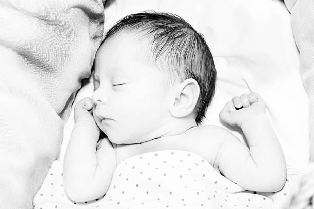 istock Newborn baby girl sleeping arms up 475710020