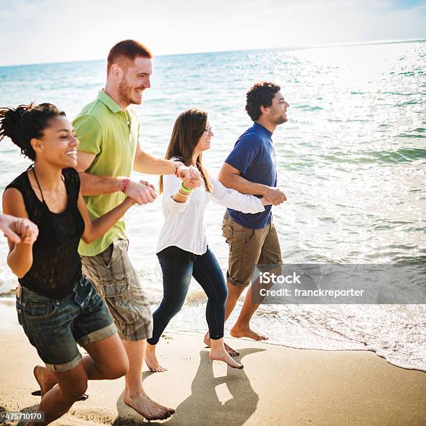 Group Of Friends Walking On The Beach Togetherness Stock Photo - Download Image Now - Teamwork, 18-19 Years, 2015