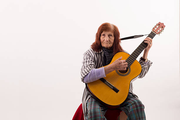 istock Funny elderly lady playing acoustic guitar 475713246