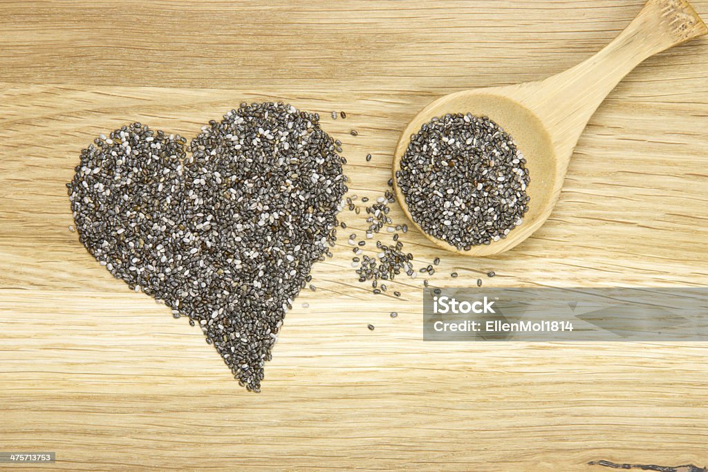 heart symbol made of black chia seeds and spoon wooden spoon filled with black chia seeds and heart symbol Antioxidant Stock Photo
