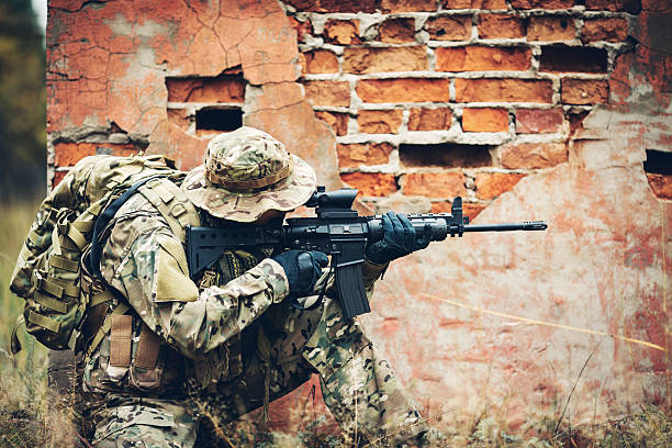 istock soldier with rifle in the forest 475715288