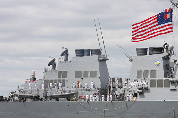 New York City, NY, USA- May 20, 2015: Members of the crew stand on the deck of the USS Barry as it sails in the Parade of Ships during Fleet Week. 