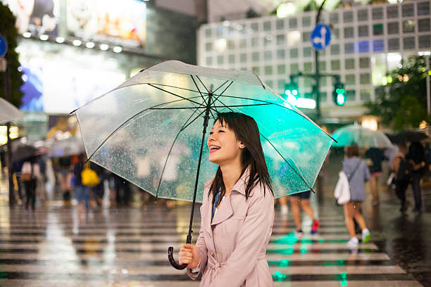 istock Laughing asian woman with umbrella 475719420
