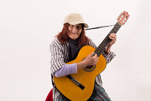 istock Funny elderly lady playing acoustic guitar 475724632
