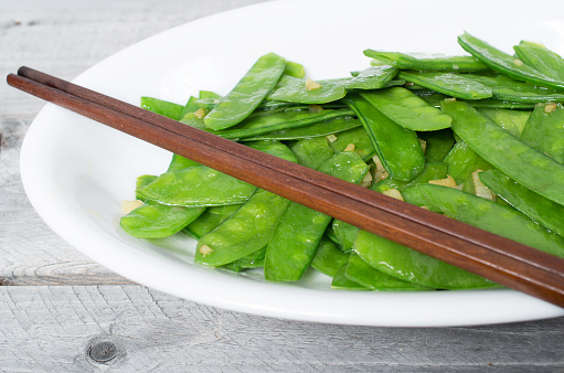 Stir fried snow peas and minced garlic isolated black background, Vietnamese cuisine