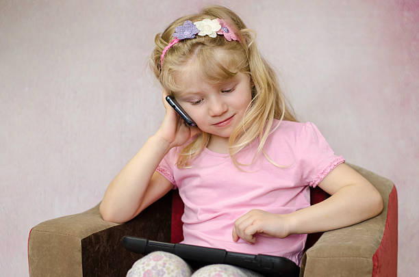 istock girl with tablet and mobile phone 475725420