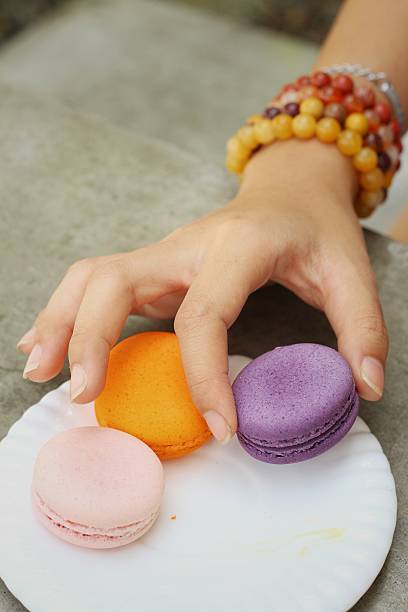 istock Hands of the woman picked a macaron 475727218