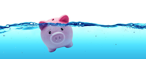 Piggy bank drowning in debt - savings to risk Piggy bank drowning in water drowning photos stock pictures, royalty-free photos & images