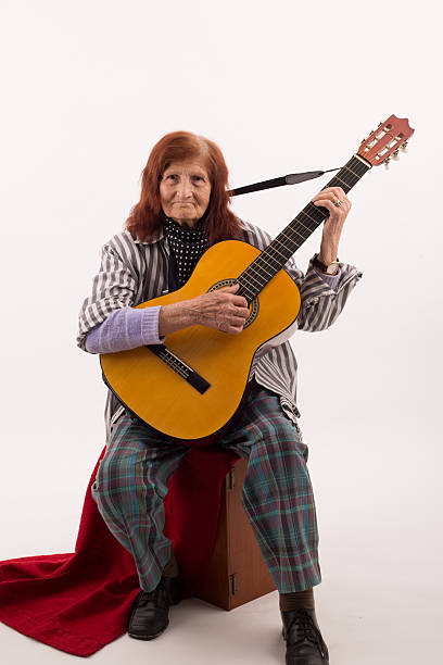 istock Funny elderly lady playing acoustic guitar 475732010