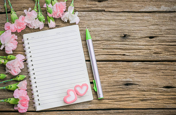 istock Blank notebook with flower on vintage wooden table 475732204
