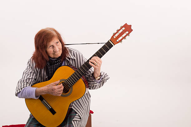 istock Funny elderly lady playing acoustic guitar 475732676