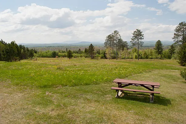 A picnic table offering a scenic view of distant mountains, in Maine.