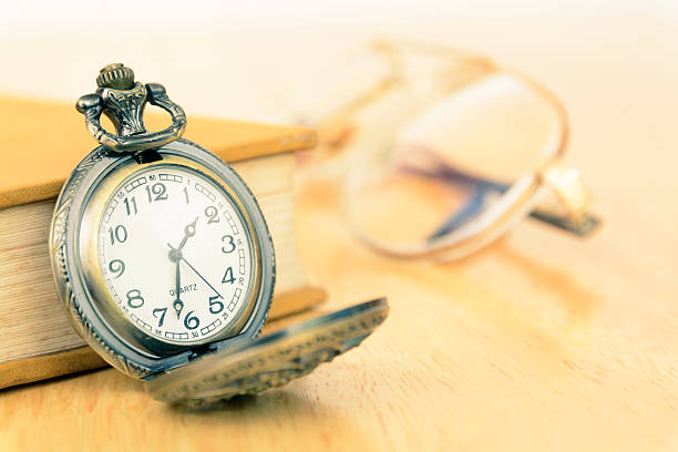 istock Vintage old pocket watch and book 475735272