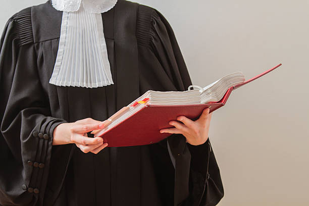 Lawyer reading canadian lawyer in toga, reading from a red law book judge law stock pictures, royalty-free photos & images