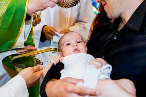 Sacerdote es baptizing little baby en una iglesia. photo