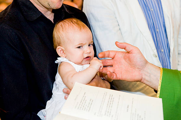 istock Priest is baptizing little baby in a church. 475743138