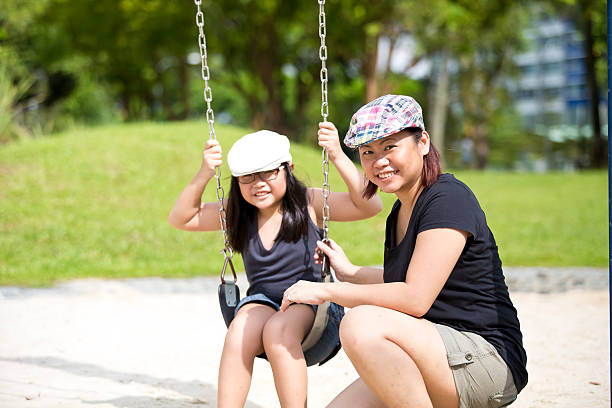 istock Young Asian mother and daughter playing in park 475743524