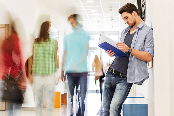 istock College student reading a book in university corridor. 475743732