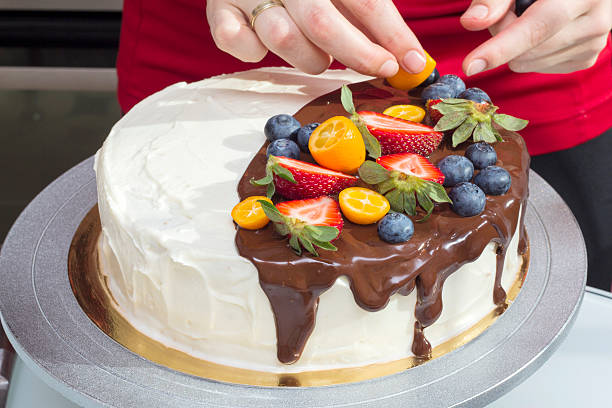 istock Chef decorates berry cake with kumquat 475744000
