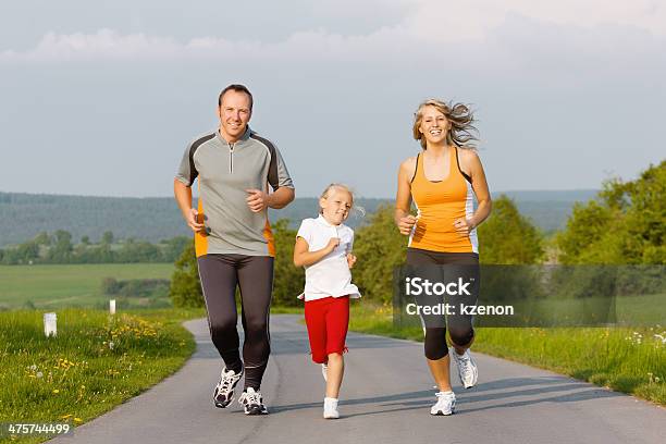 Familia Corriendo Para Deportes Al Aire Libre Foto de stock y más banco de imágenes de Actividad - Actividad, Actividades recreativas, Adulto