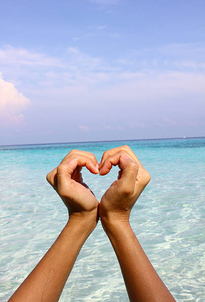 istock Closeup hands holding white sand heart shape 475744836