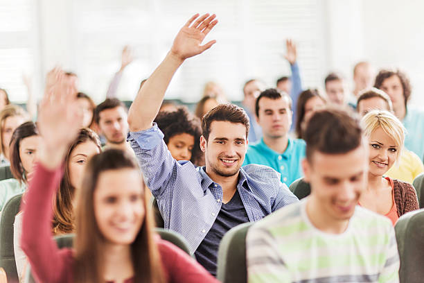istock Group of students at lecture hall with raised hands. 475745036