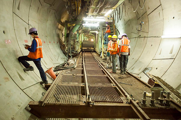 Tuneller worker installing fixture in underground subway metro construction site stock photo