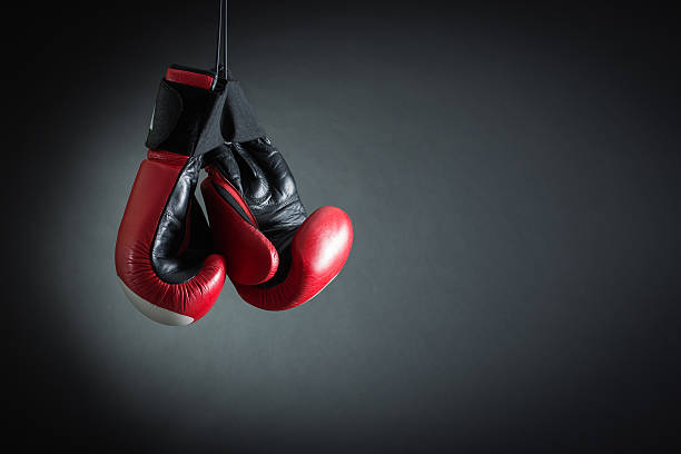 Boxing Gloves Red boxing gloves weigh against a dark background. kickboxing stock pictures, royalty-free photos & images