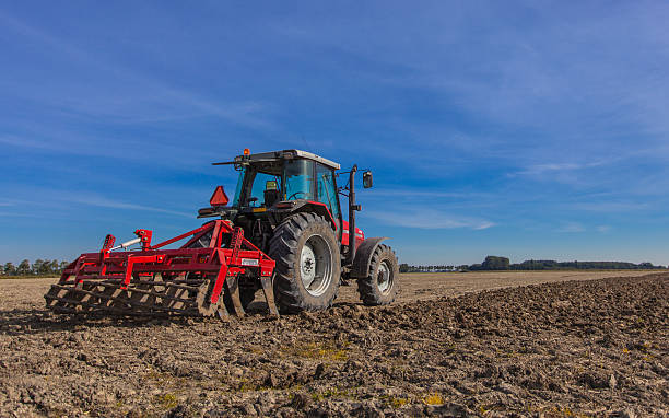 trattore con plough al lavoro - aratro foto e immagini stock