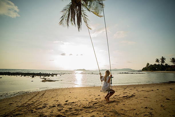 istock Young woman on a swing in a tropical Island. 475749959