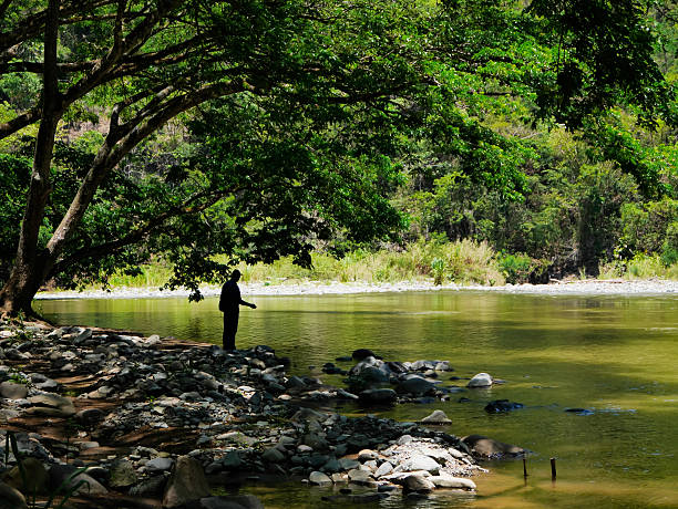 Daklak, Vietnam – July 26 2014: I have trip Daklak. I shot this image. This man was fishing in riverbank, near Draysap waterfall, Daklak, VietNam