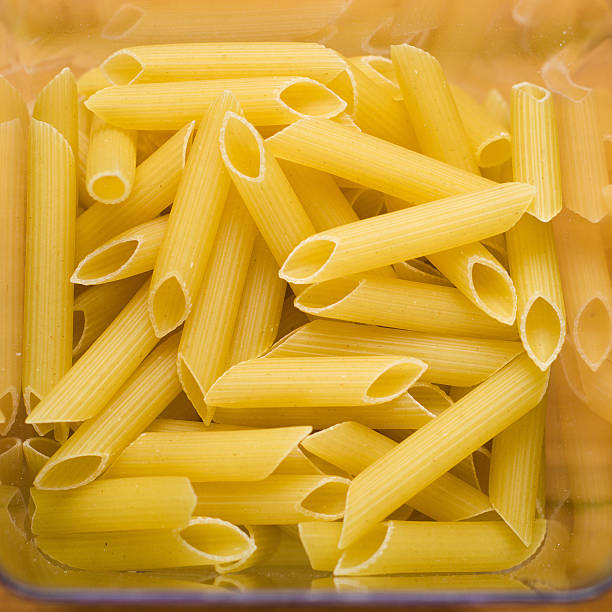 istock transparent container with uncooked spaghetti on wooden table 475751382