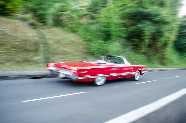 istock red convertible speeding down the road 475751708