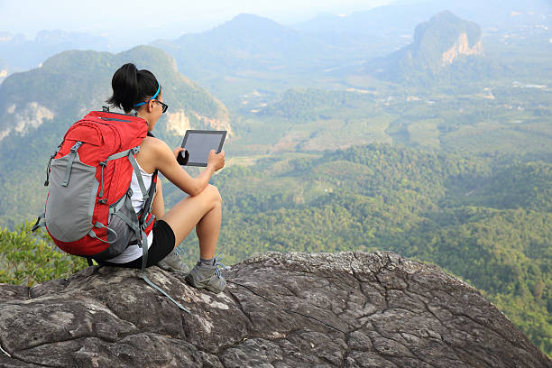 istock woman hiker use digital tablet at mountain peak cliff 475752296