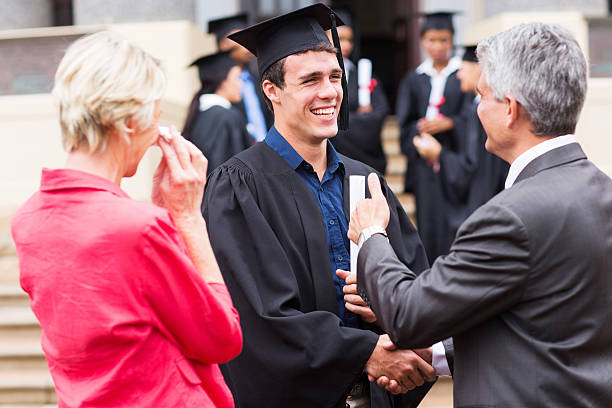 istock male graduate handshaking with his grandfather 475752729