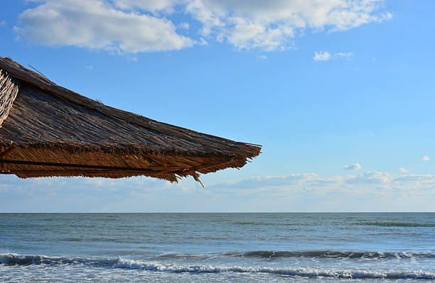 istock Straw Beach Umbrella, sea and blue sky with clouds 475753064