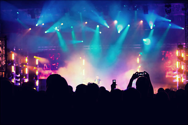 istock Cheering crowd in front of stage lights - retro photo 475753354