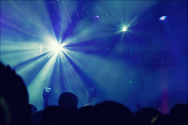istock Cheering crowd in front of stage lights - retro photo 475755992
