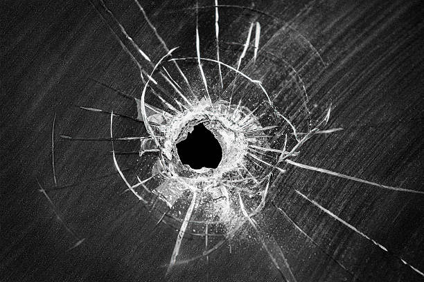 Bullet shot cracked hole on broken window glass