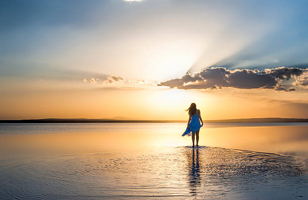 Walking into sunset Young woman walking at sunset over Salt Lake,Turkey walking beach women sadness stock pictures, royalty-free photos & images