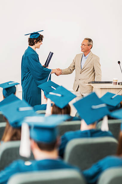 istock Student receiving diploma and shaking hands with professor. 475762656
